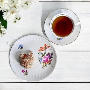 Graf von Henneberg Sammeltasse mit zartem Blumenmuster und Goldrand, gefertigt in der DDR zwischen 1972 und 1990. Die Vintage-Tasse fasst ca. 180 ml, ergänzt durch eine Untertasse (14,5 cm) und einen Kuchenteller (19 cm). Jede Tasse ein Unikat mit leicht variierenden Blütendetails. Hochwertiges Thüringer Porzellan, perfekt für Sammler und Liebhaber stilvoller Tischkultur.