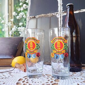 2 DDR Gläser mit VEB Druck vom Getränkekombinat Schwerin, Vintage Gläser aus der DDR, robustes klares Glas, ca. 14,5 cm hoch, 250 ml Volumen, farbiger Aufdruck mit regionalen Symbolen, guter Vintage-Zustand, ideal für Retro-Küchen, Ostalgie-Sammler oder als authentische Trinkgläser voller gelebter Geschichte.