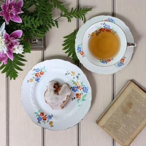 30er Jahre Zeh Scherzer Sammeltasse mit floraler Malerei in Blau, Orange und Gelb, feinem Goldrand und Reliefdetails. Historisches Porzellangedeck aus Rehau, Bayern, gefertigt um 1930 zur Weimarer Zeit, mit seltener Jubiläumsmarke der Manufaktur Zeh Scherzer & Co. AG. Ideal für Sammler, Vitrinen, Tee-Rituale oder stilvolle Interieurs mit Vintage-Charakter.